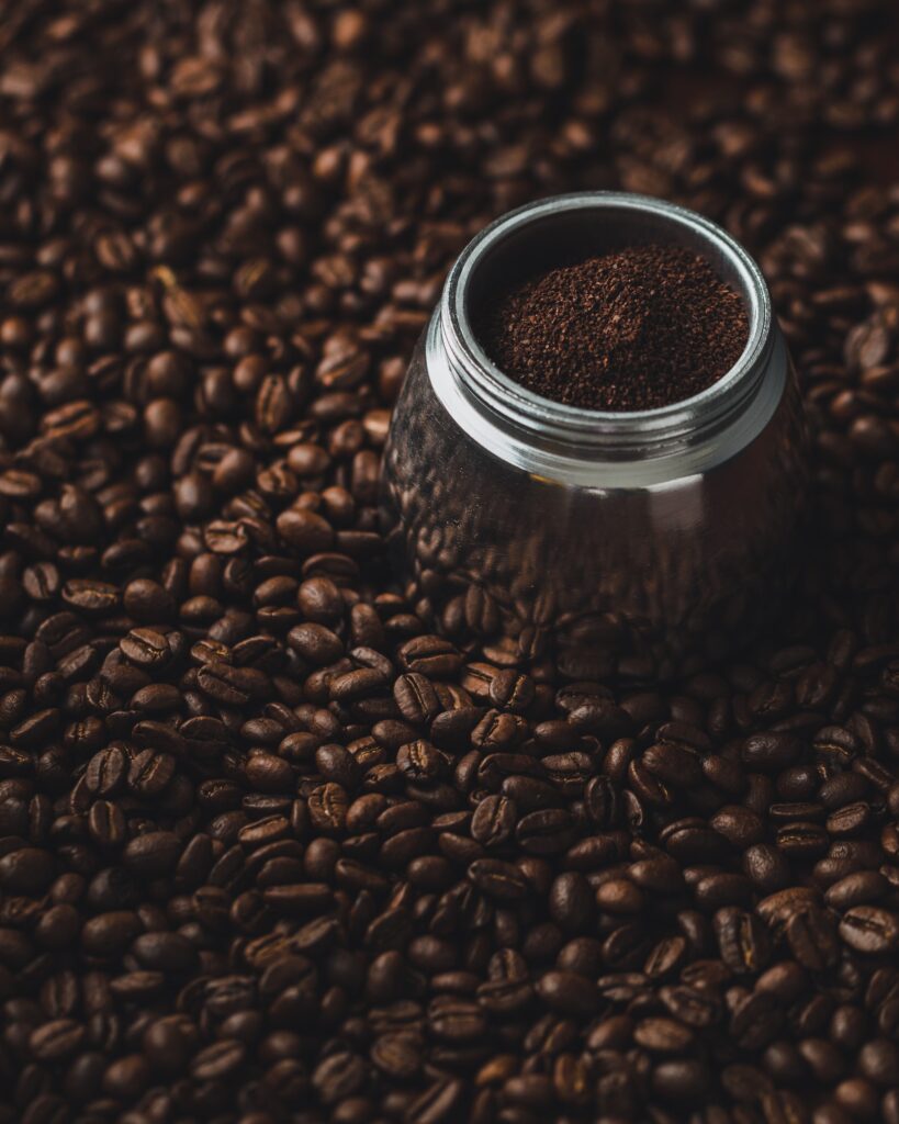 Botten av en Bialleti espressobryggare som står bland malt mörkt kaffe